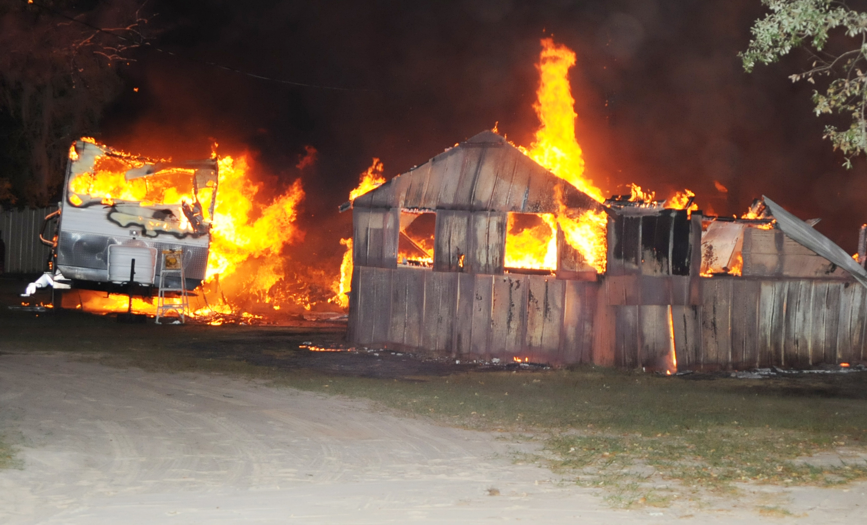 Trash fire spreads, burning large storage shed and travel 